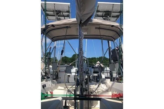 Slide: The Image of 1982 Tartan 33 sailboat cockpit with canopy and solar panels under clear blue sky. - 6