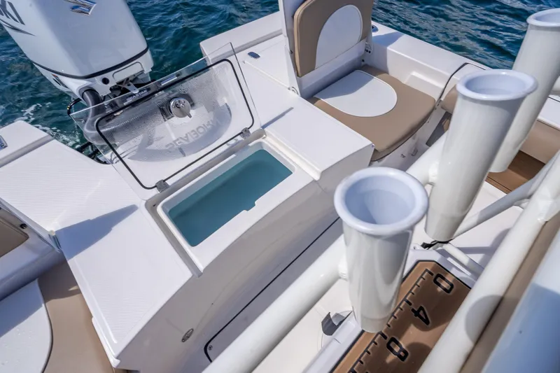 Slide: The Image of 2026 Sea Born FX22 Bay boat interior with rod holders and seating, on water. - 19