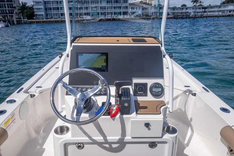 Slide: The Image of 2026 Sea Born FX22 Bay boat dashboard with steering wheel and navigation display. - 26