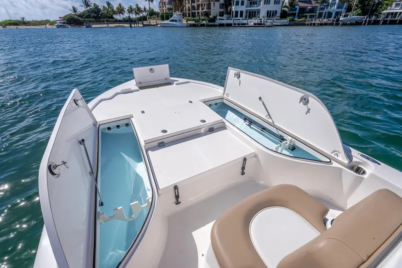 Slide: The Image of 2026 Sea Born FX22 Bay boat with open storage compartments on calm water. - 34