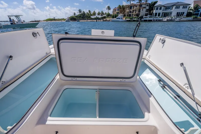 Slide: The Image of Open storage compartments on a 2026 Sea Born FX22 Bay boat, docked by waterfront homes. - 35