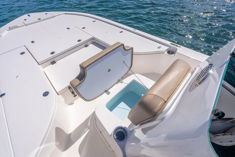 Slide: The Image of 2026 Sea Born FX22 Bay boat interior with open storage compartment on calm water. - 36
