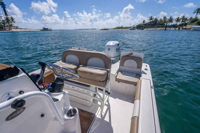 Slide: The Image of 2026 Sea Born FX22 Bay boat on serene water with clear skies and palm trees. - 39