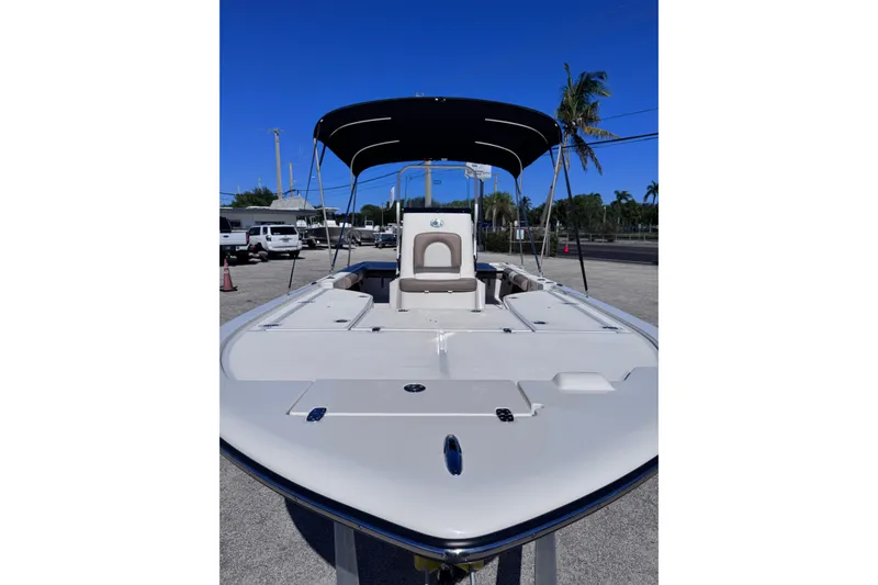Slide: The Image of 2026 Sea Born FX22 Bay boat with canopy, parked outdoors under clear blue sky. - 8