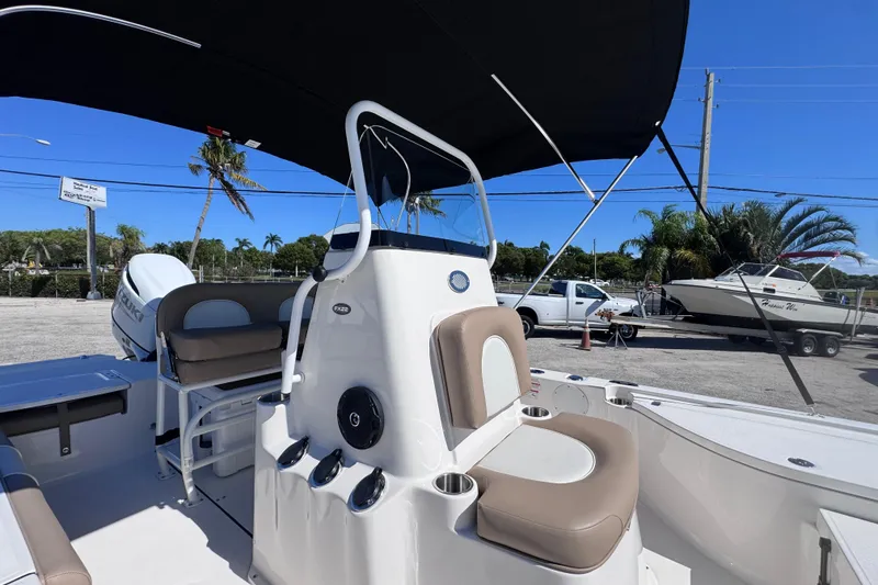 Slide: The Image of 2026 Sea Born FX22 Bay boat interior with seating and console under a canopy. - 9
