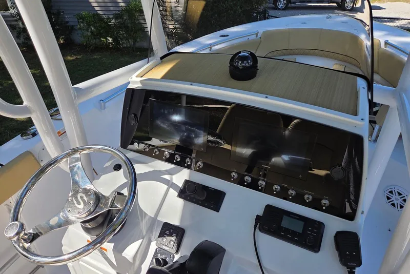 Slide: The Image of 2023 Sportsman Open 232 Center Console boat dashboard with steering wheel and navigation equipment. - 22
