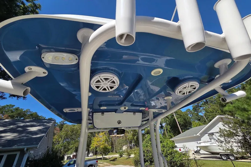 Slide: The Image of 2023 Sportsman Open 232 Center Console boat with blue T-top and rod holders. - 27