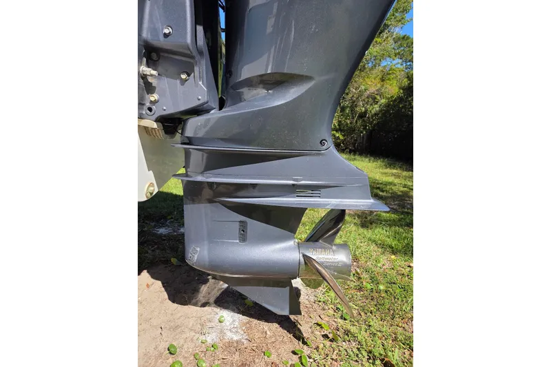 Slide: The Image of 2023 Sportsman Open 232 Center Console boat engine with Yamaha propeller in grassy area. - 42