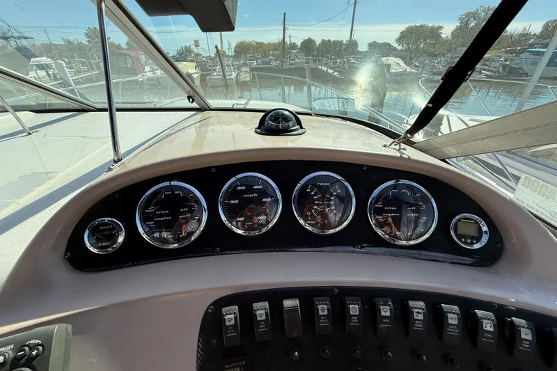 Slide: The Image of 1999 Chaparral Signature 300 dashboard with gauges and controls, marina view in background. - 16