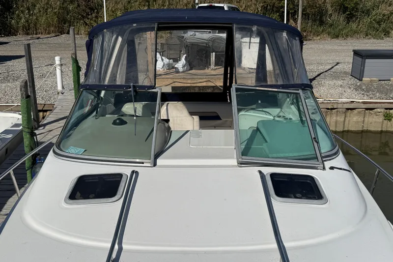 Slide: The Image of 1999 Chaparral Signature 300 boat docked, featuring open windshield and covered cockpit. - 23