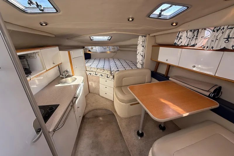 Slide: The Image of 1999 Chaparral Signature 300 cabin interior with kitchenette, dining area, and cozy sleeping space. - 24