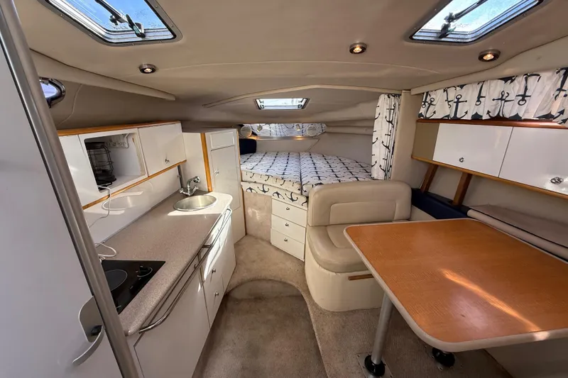 Slide: The Image of 1999 Chaparral Signature 300 cabin interior with kitchenette, seating, and bed. - 27
