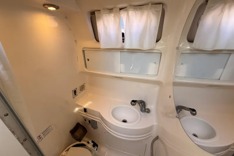 Slide: The Image of 1999 Chaparral Signature 300 boat bathroom with sink, mirror, and toilet. - 31