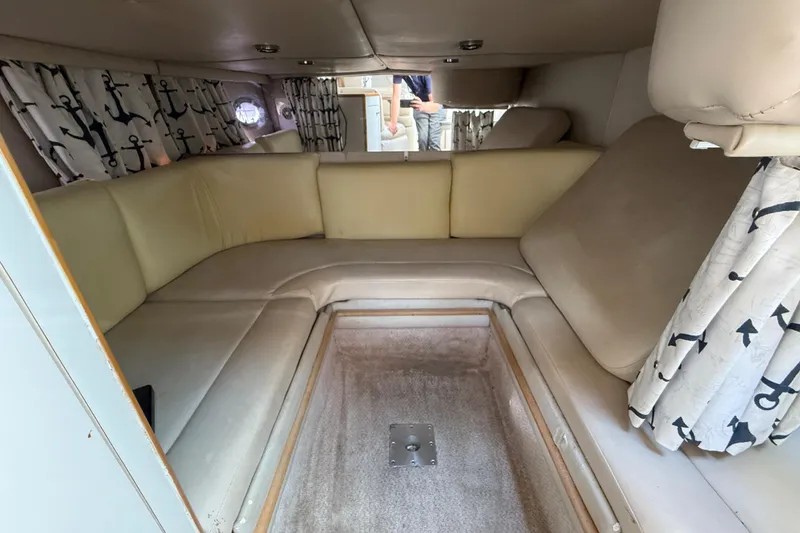 Slide: The Image of Interior of 1999 Chaparral Signature 300 boat with beige seating and anchor-patterned curtains. - 41