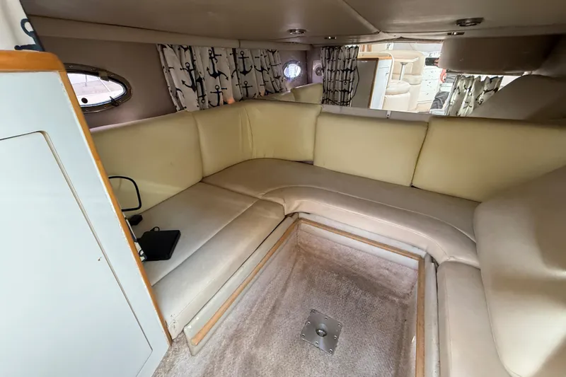 Slide: The Image of Interior of 1999 Chaparral Signature 300 boat with beige seating and anchor-patterned curtains. - 42