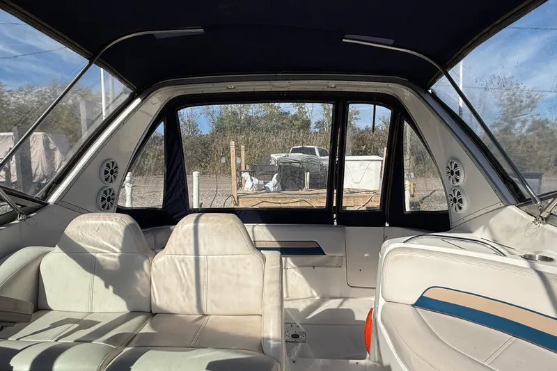 Slide: The Image of Interior of a 1999 Chaparral Signature 300 boat with white seating and blue accents. - 43