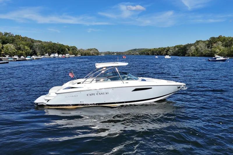 Slide: The Image of 2020 Cobalt R35 boat cruising on a scenic river with lush green banks. - 3