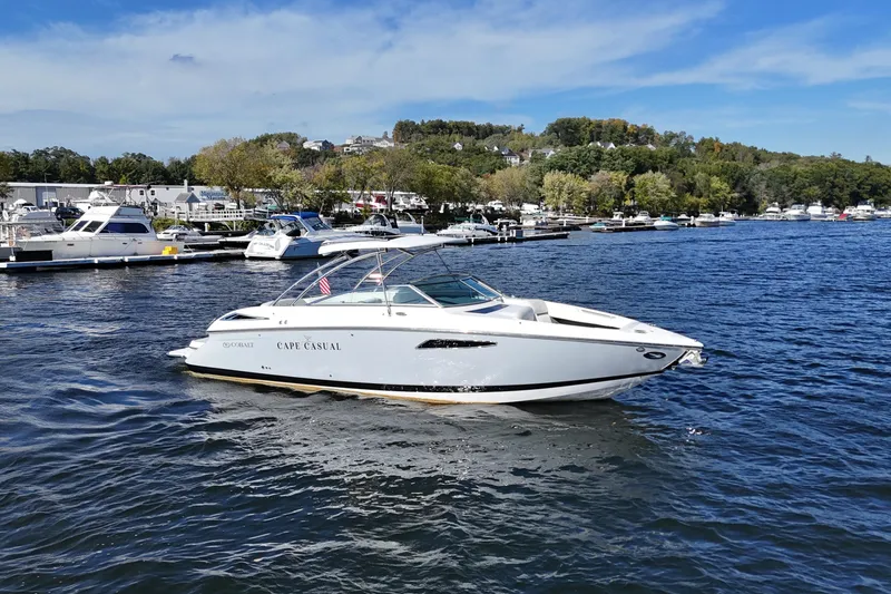 Slide: The Image of 2020 Cobalt R35 boat named "Cape Casual" on a scenic lake with marina backdrop. - 4