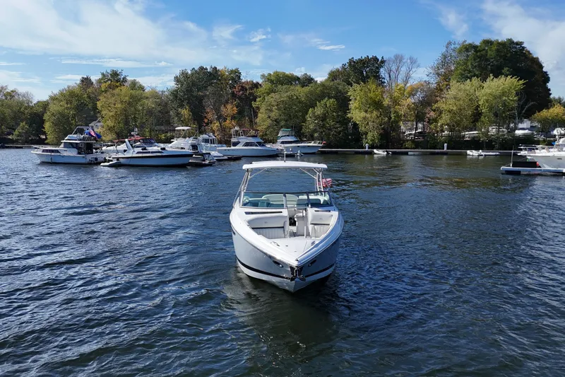 Slide: The Image of A 2020 Cobalt R35 boat on a scenic lake with surrounding trees. - 5