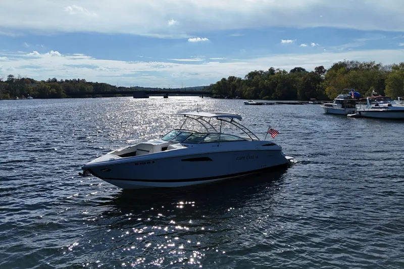 Slide: The Image of 2020 Cobalt R35 boat cruising on a scenic river under a clear blue sky. - 6