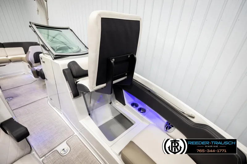 Slide: The Image of 2022 Crownline 265 SS boat interior with seating and storage, featuring modern design and lighting. - 24