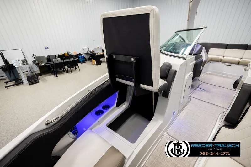 Slide: The Image of 2022 Crownline 265 SS boat interior with seating and storage, showcased in a showroom. - 26