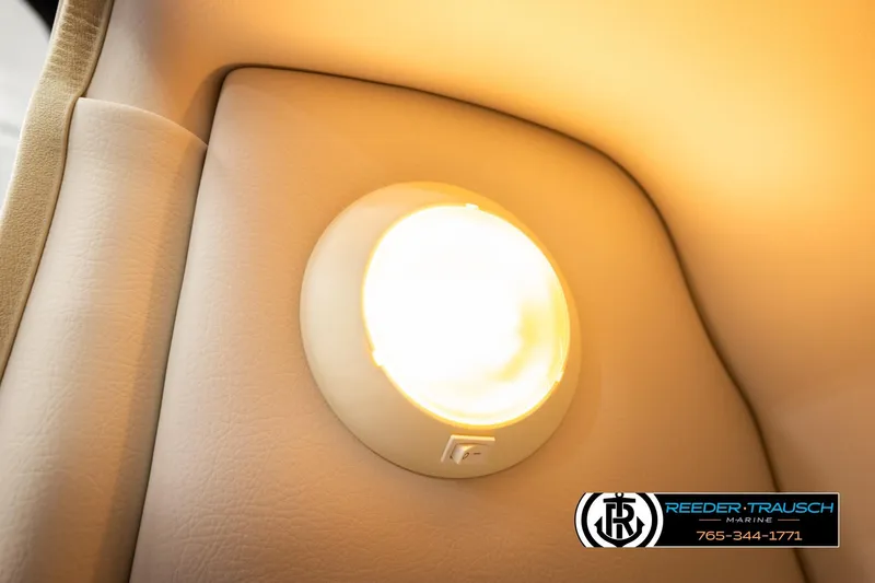 Slide: The Image of Interior light of 2022 Crownline 265 SS boat, beige upholstery, Reeder-Trausch Marine logo. - 29