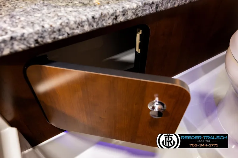 Slide: The Image of Open wooden cabinet door on 2022 Crownline 265 SS boat interior. - 31