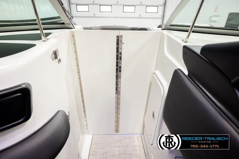 Slide: The Image of 2022 Crownline 265 SS boat interior with black seating and white paneling. - 33