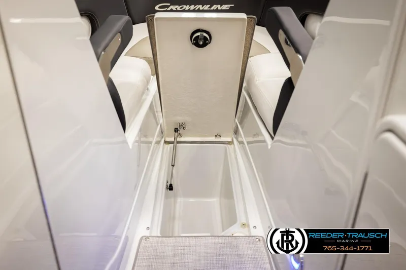 Slide: The Image of 2022 Crownline 265 SS boat interior storage compartment, open hatch, Reeder-Trausch Marine logo. - 35