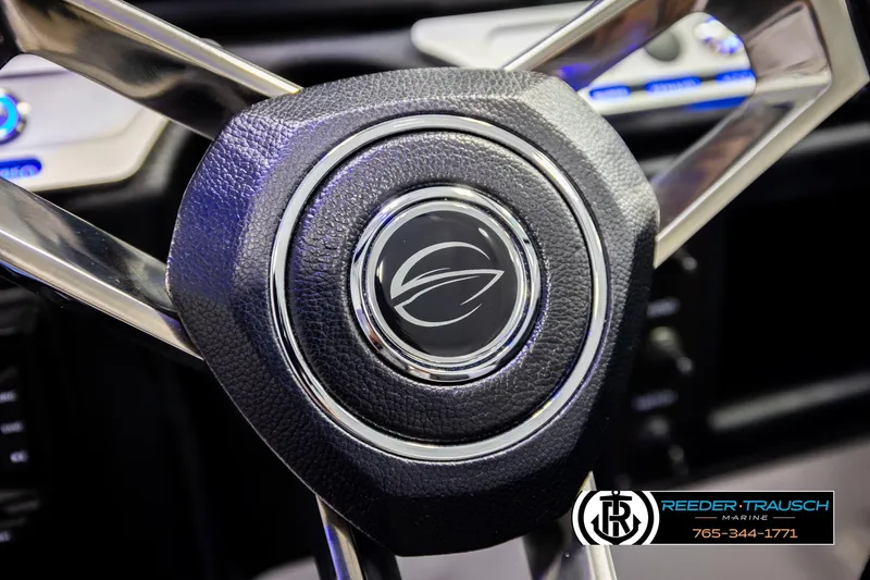 Slide: The Image of Steering wheel of 2022 Crownline 265 SS boat with logo and Reeder-Trausch Marine branding. - 44