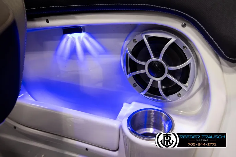 Slide: The Image of 2022 Crownline 265 SS boat interior with speaker, blue LED lighting, and cup holder. - 57
