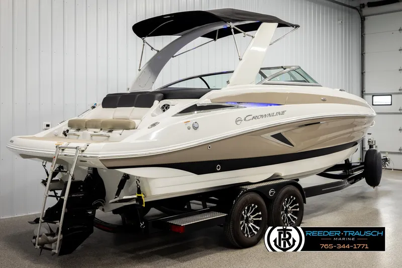 Slide: The Image of 2022 Crownline 265 SS boat on trailer in showroom, featuring sleek design and modern amenities. - 6