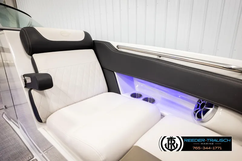 Slide: The Image of 2022 Crownline 265 SS boat interior with white seating, cup holders, and blue LED lighting. - 60