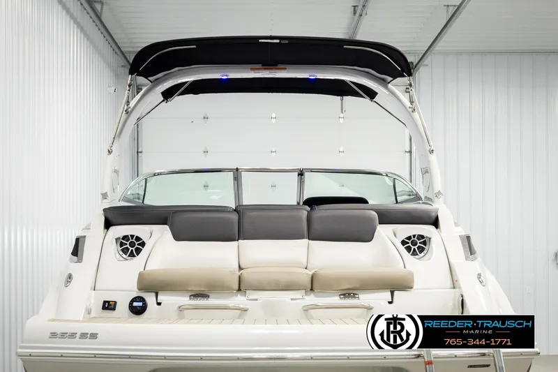 Slide: The Image of 2022 Crownline 265 SS boat in showroom, rear view with seating and speakers. - 7