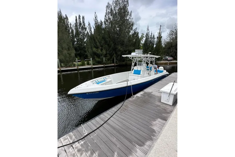 Slide: The Image of 2021 Custom Infusion 34 CC boat docked on a calm waterway. - 1