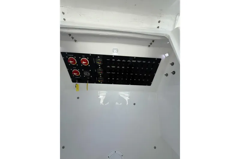 Slide: The Image of Electrical panel inside 2021 Custom Infusion 34 CC boat, featuring switches and gauges. - 15