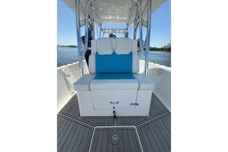 Slide: The Image of 2021 Custom Infusion 34 CC boat interior with blue and white seating, on calm water. - 16
