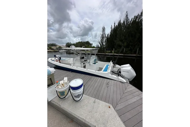 Slide: The Image of Custom Infusion 34 CC boat docked, 2021 model, with fishing gear and cloudy sky. - 2