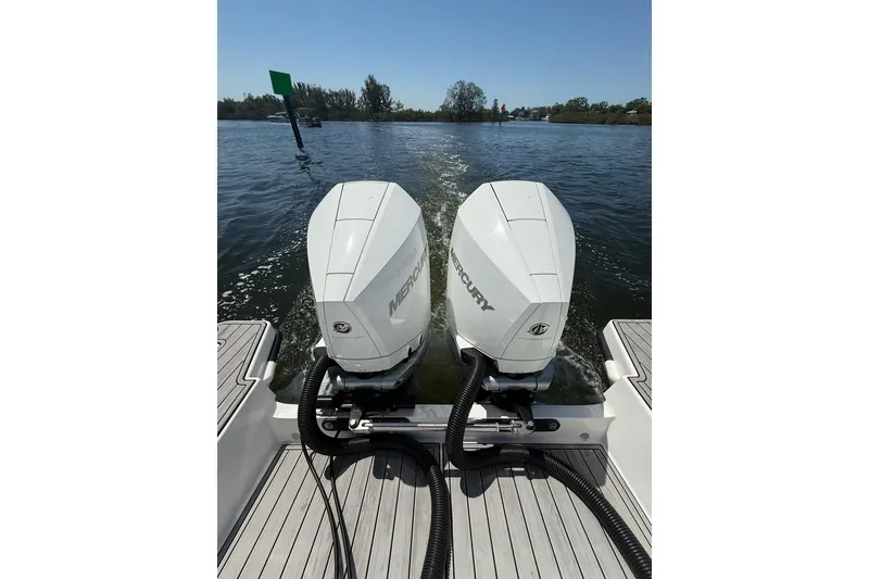 Slide: The Image of Twin Mercury outboard engines on 2021 Custom Infusion 34 CC boat, cruising on a sunny day. - 21