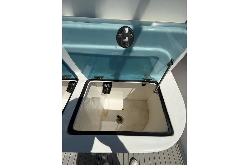 Slide: The Image of Open storage compartment on 2021 Custom Infusion 34 CC boat, featuring a blue lid. - 25