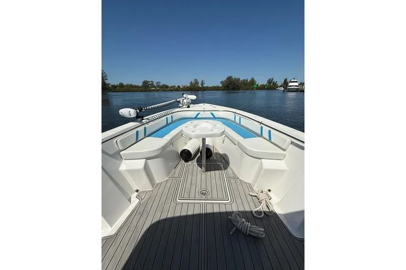 Slide: The Image of 2021 Custom Infusion 34 CC boat interior with seating and table on calm water. - 4