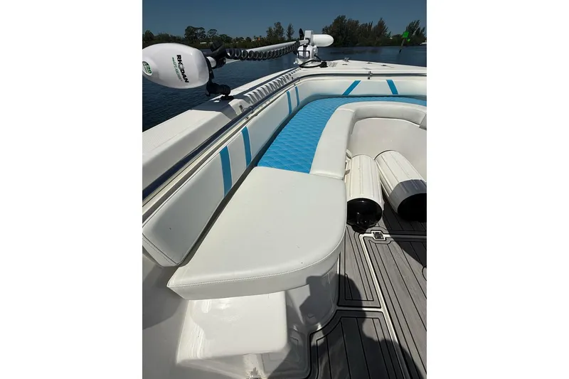 Slide: The Image of Custom Infusion 34 CC 2021 boat interior with white and blue seating, docked on water. - 5