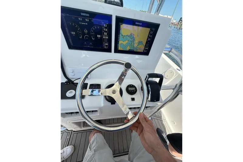 Slide: The Image of Steering console of 2021 Custom Infusion 34 CC boat with navigation displays. - 54