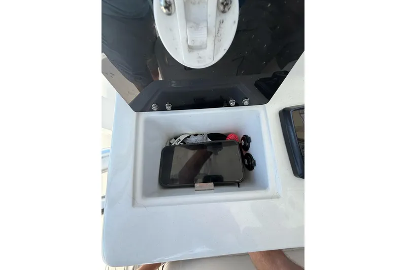 Slide: The Image of Storage compartment on 2021 Custom Infusion 34 CC boat with phone and accessories. - 57