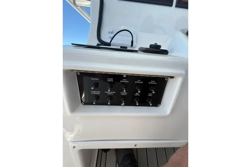 Slide: The Image of Control panel on a 2021 Custom Infusion 34 CC boat, featuring various light switches. - 58