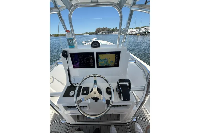 Slide: The Image of 2021 Custom Infusion 34 CC boat dashboard with navigation screens and steering wheel. - 60