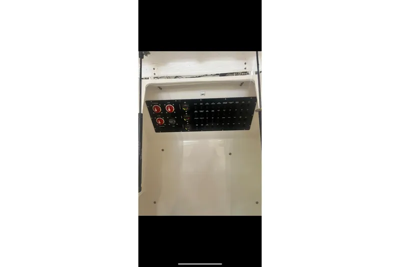Slide: The Image of Electrical panel inside 2021 Custom Infusion 34 CC boat, featuring switches and controls. - 71