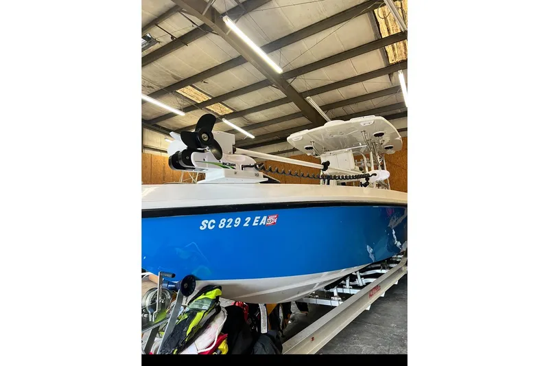 Slide: The Image of 2021 Custom Infusion 34 CC boat in a warehouse, blue hull, visible registration number. - 72