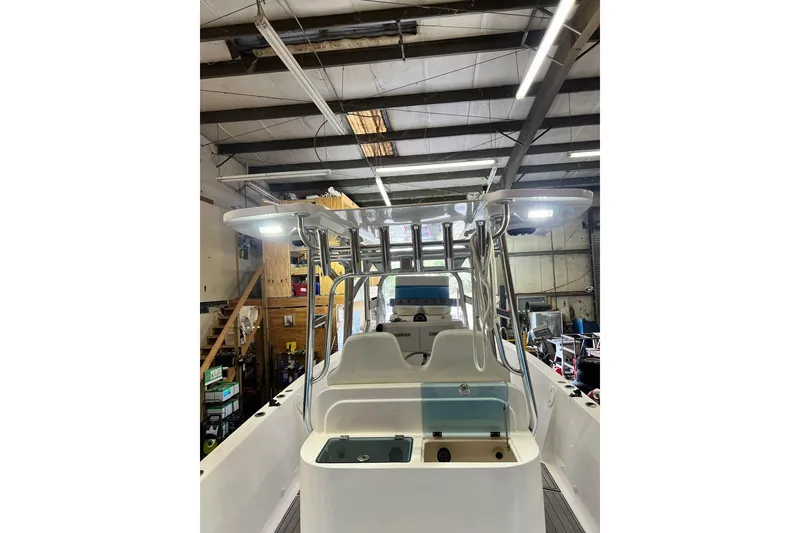Slide: The Image of Custom Infusion 34 CC 2021 boat in a workshop, showcasing helm and seating area. - 76